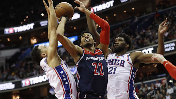 Jan 9, 2019; Washington, DC, USA; Washington Wizards forward Otto Porter Jr. (22) shoots the ball as Philadelphia 76ers guard Landry Shamet (1) and Philadelphia 76ers center Joel Embiid (21) defend in the fourth quarter at Capital One Arena. The Wizards won 123-106. Mandatory Credit: Geoff Burke-Imagn Images