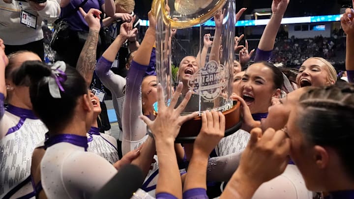 LSU gymnasts celebrate with the championship trophy after Session 2 competition at the SEC Gymnastics Championship at Legacy Arena in Birmingham, Alabama.