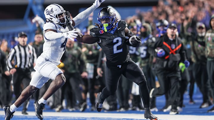 Running back Ashton Jeanty #2 of the Boise State Broncos pushes off the tackle of safety Kitan Crawford #4 of the Nevada Wolf Pack during the first half at Albertsons Stadium on November 9, 2024 in Boise, Idaho.