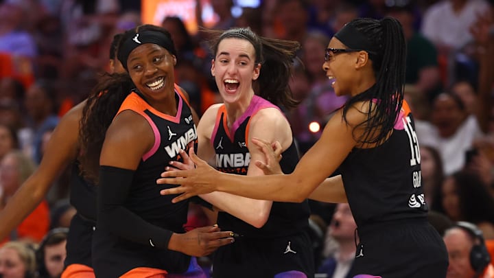 Jul 20, 2024; Phoenix, AZ, USA; Team WNBA player Arike Ogunbowale celebrates with Caitlin Clark and Allisha Gray after making a three point shot during the second half against the USA Women's National Team at Footprint Center. Mandatory Credit: Mark J. Rebilas-Imagn Images