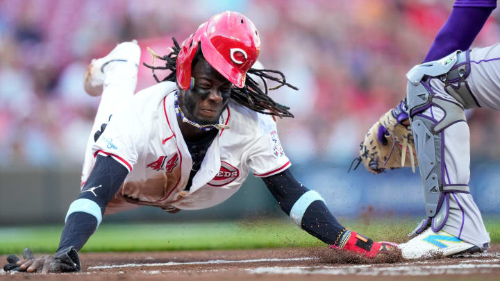 Cincinnati Reds shortstop Elly De La Cruz (44) dives across home plate on a steal attempt but is tagged out by Colorado Rockies catcher Elias Díaz (35) for the final out of the first inning of the MLB National League game between the Cincinnati Reds and the Colorado Rockies at Great American Ball Park in downtown Cincinnati on Monday, July 8, 2024. The score was 0-0 after three innings.