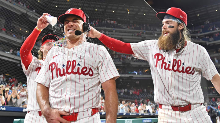May 22, 2024; Philadelphia, Pennsylvania, USA; Philadelphia Phillies catcher J.T. Realmuto (10) has water dumped on him by second base Bryson Stott (5) and outfielder Brandon Marsh (16) after win against the Texas Rangers at Citizens Bank Park. Mandatory Credit: Eric Hartline-USA TODAY Sports