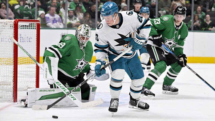 Nov 20, 2024; Dallas, Texas, USA; San Jose Sharks left wing Fabian Zetterlund (20) attempts to poke the puck past Dallas Stars goaltender Jake Oettinger (29) during the third period at the American Airlines Center. Mandatory Credit: Jerome Miron-Imagn Images