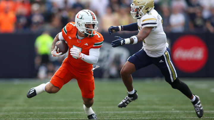 Nov 9, 2024; Atlanta, Georgia, USA; Miami Hurricanes wide receiver Xavier Restrepo (7) runs past Georgia Tech Yellow Jackets defensive back Clayton Powell-Lee (5) after a catch in the first quarter at Bobby Dodd Stadium at Hyundai Field. Mandatory Credit: Brett Davis-Imagn Images