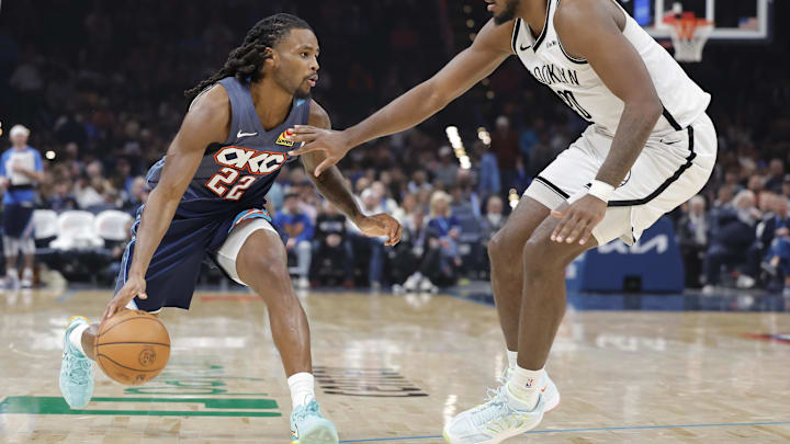 Feb 20, 2026; Oklahoma City, Oklahoma, USA; Oklahoma City Thunder guard Cason Wallace (22) drives down the court as Brooklyn Nets center Day'ron Sharpe (20) defends during the second half at Paycom Center.