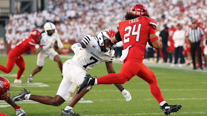 Sep 27, 2025; Ames, Iowa, USA; Arizona Wildcats running back Quincy Craig (24) is tackled by Iowa State Cyclones defensive back Tre Bell (7) during the first half at Jack Trice Stadium. Mandatory Credit: Reese Strickland-Imagn Images Sep 27, 2025; Ames, Iowa, USA; Arizona Wildcats running back Quincy Craig (24) is tackled by Iowa State Cyclones defensive back Tre Bell (7) during the first half at Jack Trice Stadium. Mandatory Credit: Reese Strickland-Imagn Images