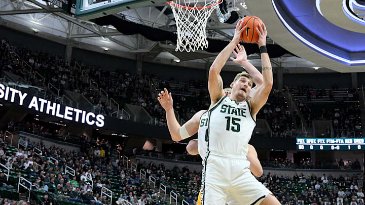 Dec 16, 2025; East Lansing, Michigan, USA;  Michigan State Spartans center Carson Cooper (15) grabs a rebound against the Toledo Rockets at Jack Breslin Student Events Center. Mandatory Credit: Dale Young-Imagn Images