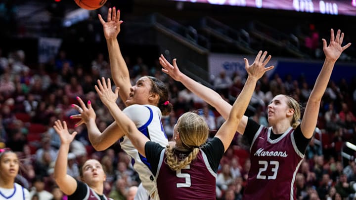 Johnston's Amani Jenkins (42) takes a shot at the basket against Dowling's Ellie Olson (5) and Ellie Muller (23) Friday during the Class 5A state title game.