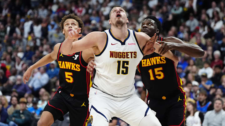 Jan 1, 2025; Denver, Colorado, USA; Atlanta Hawks guard Dyson Daniels (5) an center Clint Capela (15) and Denver Nuggets center Nikola Jokic (15) in the second quarter at Ball Arena. Mandatory Credit: Ron Chenoy-Imagn Images