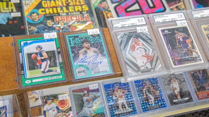Rare sports cards, some graded for quality, sit in a display shelf at the new shop Stooges Comics and Collectibles in the Oak Cliff Park shopping center in Peoria.