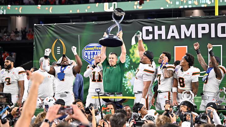 Dec 31, 2025; Arlington, TX, USA; Miami Hurricanes head coach Mario Cristobal lifts the Cotton Bowl trophy after defeating the Ohio State Buckeyes during the 2025 Cotton Bowl and quarterfinal game of the College Football Playoff at AT&T Stadium. Mandatory Credit: Jerome Miron-Imagn Images