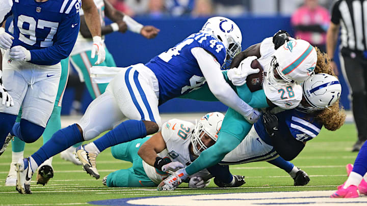 Oct 20, 2024; Indianapolis, Indiana, USA; Miami Dolphins running back De'Von Achane (28) is tackled by Indianapolis Colts linebacker Grant Stuard (41) during the first quarter at Lucas Oil Stadium. Mandatory Credit: Marc Lebryk-Imagn Images
