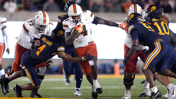 Oct 5, 2024; Berkeley, California, USA; Miami Hurricanes running back Mark Fletcher Jr. (center) carries the ball against California Golden Bears defensive back Miles Williams (center left) during the second quarter at California Memorial Stadium. Mandatory Credit: Darren Yamashita-Imagn Images