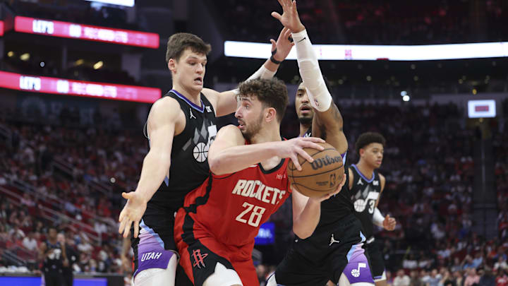 Apr 2, 2025; Houston, Texas, USA; Houston Rockets center Alperen Sengun (28) looks to pass the ball as Utah Jazz center Walker Kessler (24) and forward KJ Martin (99) defend during the fourth quarter at Toyota Center. Mandatory Credit: Troy Taormina-Imagn Images