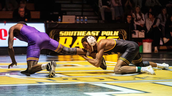 Southeast Polk’s Eddie Woody Jr. wrestles Johnston’s Michael Dyett on Dec. 4, 2025, at Southeast Polk High School.