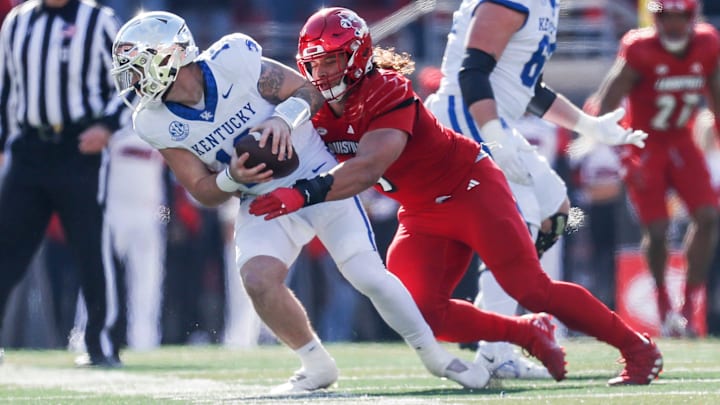 Louisville Cardinals defensive lineman Ashton Gillotte (9) brings down Kentucky Wildcats quarterback Devin Leary (13) for a sack in the first half Saturday. Nov. 25, 2023.