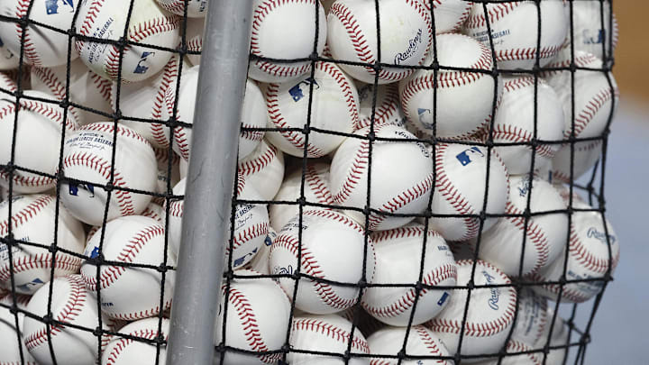 A bucket of baseball sits on the field before the game between the Colorado Rockies and the Miami Marlins.