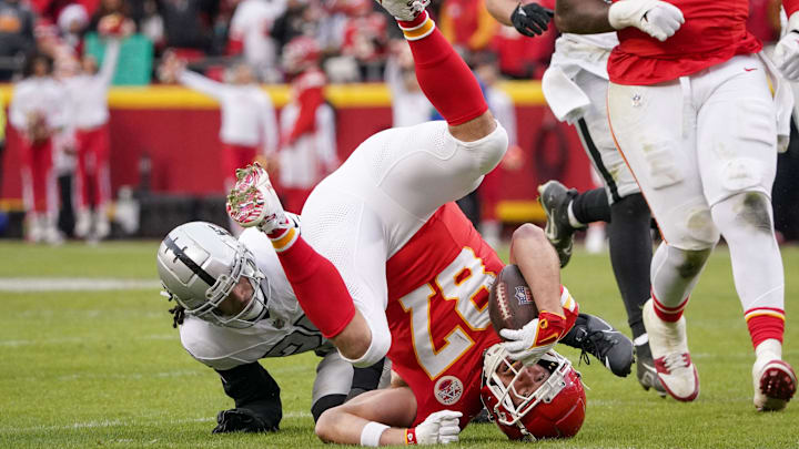 Dec 25, 2023; Kansas City, Missouri, USA; Kansas City Chiefs tight end Travis Kelce (87) is tackled by Las Vegas Raiders safety Tre'von Moehrig (25) during the game at GEHA Field at Arrowhead Stadium. Mandatory Credit: Denny Medley-Imagn Images