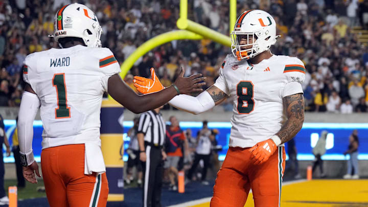 Miami Hurricanes quarterback Cam Ward (1) is congratulated by tight end Elijah Arroyo (8) after scoring a touchdown against the California Golden Bears during the fourth quarter at California Memorial Stadium.