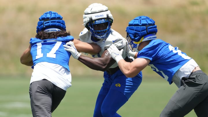 May 21, 2024, Thousand Oaks, California, USA; Los Angeles Rams linebacker Byron Young (0) is defended by wide receiver Puka Nacua (17) and tight end Colby Parkinson (86) during organized team activities at Cal Lutheran University. Mandatory Credit: Kirby Lee-USA TODAY Sports