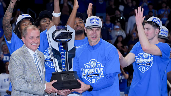 Mar 14, 2026; Charlotte, NC, USA; Duke Blue Devils head coach Jon Scheyer receives the trophy after defeating the Virginia Cavaliers in the men's ACC Conference Tournament Championship.