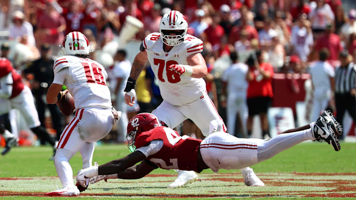Sep 13, 2025; Tuscaloosa, Alabama, USA; Wisconsin Badgers quarterback Danny O'Neil (18) outruns Alabama Crimson Tide linebacker Yhonzae Pierre (42) during the second half at Saban Field at Bryant-Denny Stadium.