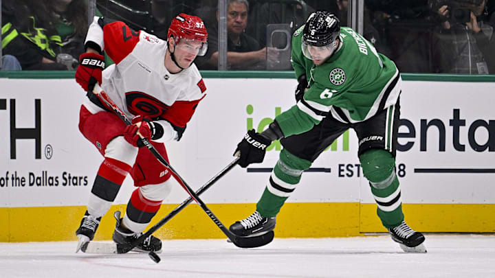 Oct 25, 2025; Dallas, Texas, USA; Carolina Hurricanes right wing Andrei Svechnikov (37) and Dallas Stars defenseman Lian Bichsel (6) battle for the puck during the game between the Stars and the Hurricanes at the American Airlines Center. Mandatory Credit: Jerome Miron-Imagn Images