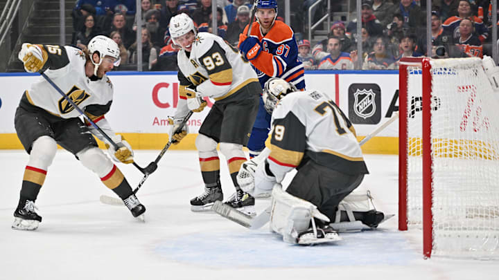 Dec 21, 2025; Edmonton, Alberta, CAN; Vegas Golden Knights (15) races towards Vegas Golden Knights right wing Mitch Marner (93) as he battles with Edmonton Oilers center Connor McDavid (97) in front of Vegas Golden Knights goalie Carter Hart (79) during the first period at Rogers Place. Mandatory Credit: Walter Tychnowicz-Imagn Images