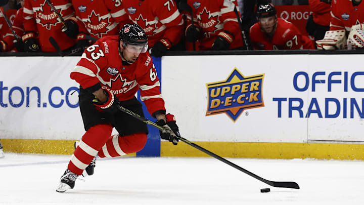 Feb 20, 2025; Boston, MA, USA; [teammates look on, Team Canada forward Brad Marchand (63) carries the puck during the 4 Nations Face-Off ice hockey championship game against the United States at TD Garden. Mandatory Credit: Winslow Townson-Imagn Images