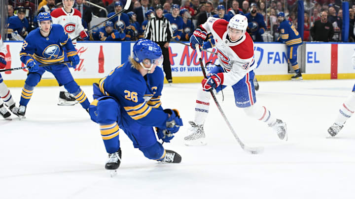 Nov 11, 2024; Buffalo, New York, USA; Montreal Canadiens defenseman Lane Hutson (48) shoots the puck with Buffalo Sabres defenseman Rasmus Dahlin (26) defending in the third period at KeyBank Center. Mandatory Credit: Mark Konezny-Imagn Images