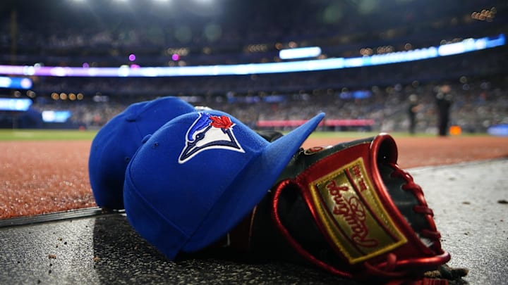 A pair of Toronto Blue Jays hats and glove in the dugout during a game against the Minnesota Twins at Rogers Centre in 2024.