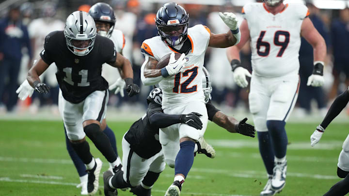 Dec 7, 2025; Paradise, Nevada, USA; Denver Broncos running back RJ Harvey (12) carries the ball as. Las Vegas Raiders safety Lonnie Johnson Jr. (32) defends during the first half at Allegiant Stadium. Mandatory Credit: Kirby Lee-Imagn Images Dec 7, 2025; Paradise, Nevada, USA; Denver Broncos running back RJ Harvey (12) carries the ball as. Las Vegas Raiders safety Lonnie Johnson Jr. (32) defends during the first half at Allegiant Stadium. Mandatory Credit: Kirby Lee-Imagn Images