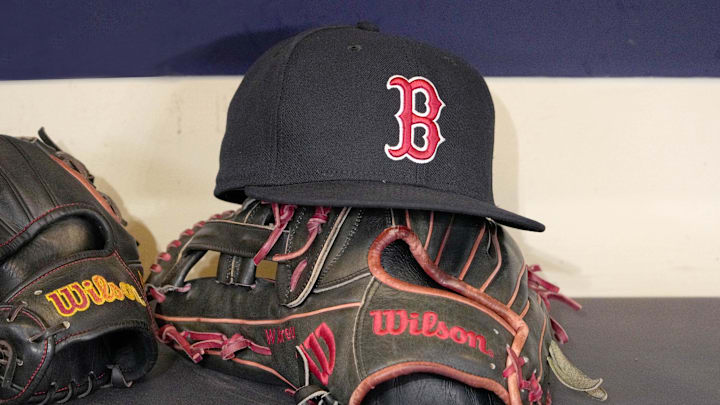 May 27, 2025; Milwaukee, Wisconsin, USA; A Boston Red Sox hat and glove sit in the dug out before a game against the Milwaukee Brewers at American Family Field. Mandatory Credit: Michael McLoone-Imagn Images
