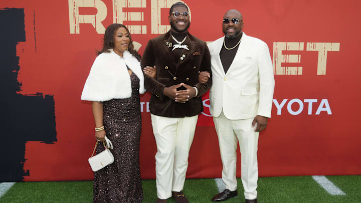 Alabama Crimson Tide offensive guard Tyler Booker with his parents, Tashona Booker and William Booker, on the red carpet before the 2025 NFL Draft at Lambeau Field.