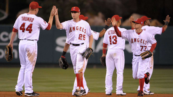 May 23, 2011; Anaheim, CA, USA; Los Angeles Angles first baseman Mark Trumbo (44) exchanges high fives with center fielder Peter Bourjos (25), center, and left fielder Reggie Willits (77) after the game against the Oakland Athletics at Angel Stadium. The Angels defeated the Athletics 4-1.
