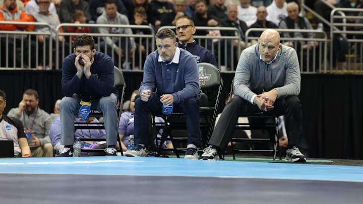 Penn State wrestling coach Cael Sanderson and his staff watch the 141-pound championship match at the 2024 NCAA Wrestling Championships. 