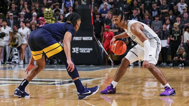 Feb 14, 2026; Orlando, Florida, USA; UCF Knights guard Themus Fulks (1) handles the ball in front of West Virginia Mountaineers guard Jasper Floyd (1) during the second half at Addition Financial Arena. Mandatory Credit: Mike Watters-Imagn Images