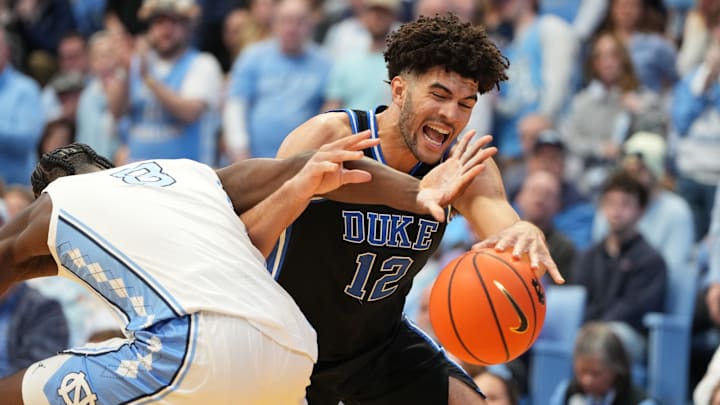 Feb 7, 2026; Chapel Hill, North Carolina, USA;  North Carolina Tar Heels forward Caleb Wilson (8) and Duke Blue Devils forward Cameron Boozer (12) fight for the ball in the first  half at Dean E. Smith Center. Mandatory Credit: Bob Donnan-Imagn Images