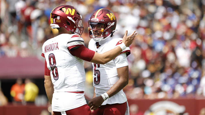 Washington Commanders quarterback Jayden Daniels (5) talks to Commanders quarterback Marcus Mariota (8) on the field during the first quarter against the New York Giants at Northwest Stadium. Washington Commanders quarterback Jayden Daniels (5) talks to Commanders quarterback Marcus Mariota (8) on the field during the first quarter against the New York Giants at Northwest Stadium.