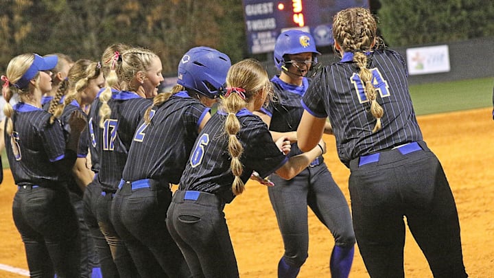 Lexington softball team at homeplate greeting teammate after a home run.