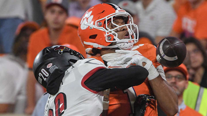 Nov 2, 2024; Clemson, South Carolina, USA; Louisville Cardinals defensive back Tayon Holloway (20) breaks up a pass intended for Clemson Tigers wide receiver T.J. Moore (1) during the second quarter at Memorial Stadium. Mandatory Credit: Ken Ruinard-Imagn Images