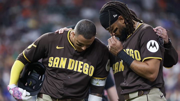 Apr 20, 2025; Houston, Texas, USA;San Diego Padres third baseman Manny Machado (13) and right fielder Fernando Tatis Jr. (23) pray for San Diego Padres designated hitter Luis Arraez (4) after he colliding with Houston Astros first baseman Christian Walker (8) (not pictured )on the first base line in the first inning at Daikin Park.Arraez was carted off the field . Mandatory Credit: Thomas Shea-Imagn Images