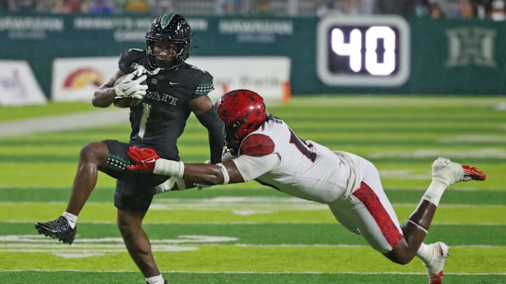 Nov 8, 2025; Honolulu, Hawaii, USA; San Diego State Aztecs defensive lineman Ryan Henderson (10) tries to pull down Hawaii Rainbow Warriors wide receiver Brandon White (1).