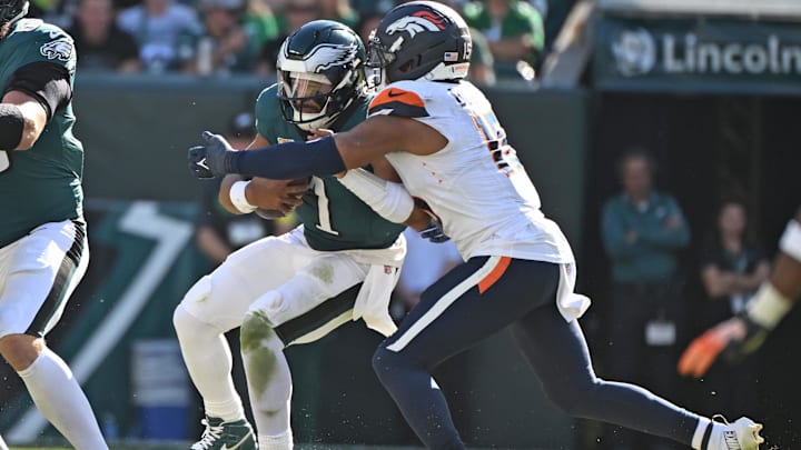 Oct 5, 2025; Philadelphia, Pennsylvania, USA; Philadelphia Eagles quarterback Jalen Hurts (1) is sacked by Denver Broncos linebacker Nik Bonitto (15) at Lincoln Financial Field. Mandatory Credit: Eric Hartline-Imagn Images