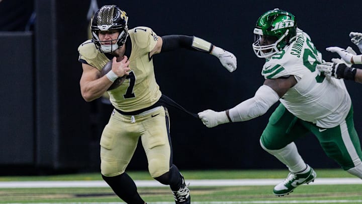 Dec 21, 2025; New Orleans, Louisiana, USA;  New York Jets defensive tackle Khalen Saunders (99) attempts to tackle New Orleans Saints tight end Taysom Hill (7) during the second half  at Caesars Superdome. Mandatory Credit: Stephen Lew-Imagn Images