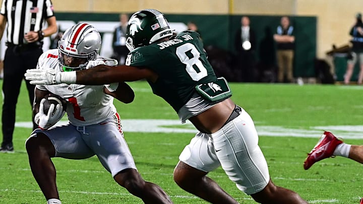 Sep 28, 2024; East Lansing, Michigan, USA;  Michigan State Spartans defensive lineman Anthony Jones (8) tackles Ohio State Buckeyes wide receiver Jeremiah Smith (4) in the first quarter at Spartan Stadium. Mandatory Credit: Dale Young-Imagn Images