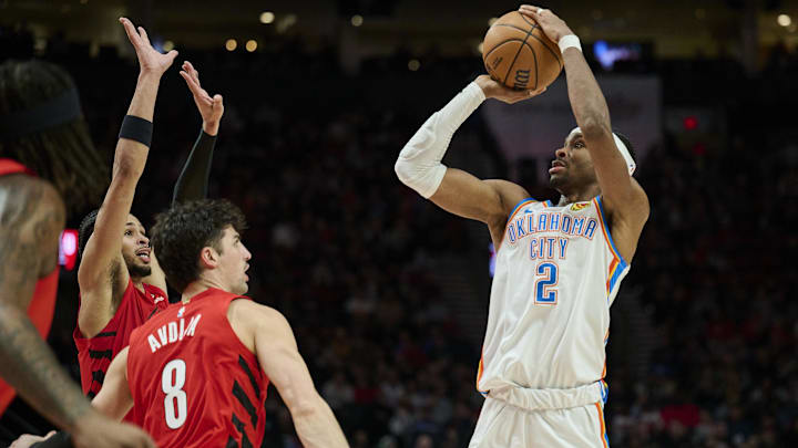 Jan 26, 2025; Portland, Oregon, USA; Oklahoma City Thunder guard Shai Gilgeous-Alexander (2) shoots a jump shot during the second half against Portland Trail Blazers forward Deni Avdija (8) and forward Toumani Camara (33) at Moda Center. Mandatory Credit: Troy Wayrynen-Imagn Images