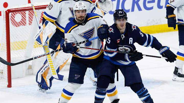 Feb 27, 2024; Winnipeg, Manitoba, CAN; St. Louis Blues defenseman Justin Faulk (72) jostles for position with Winnipeg Jets forward Mark Scheifele (55) in front of St. Louis Blues goalie Joel Hofer (30) during the third period at Canada Life Centre. Mandatory Credit: Terrence Lee-USA TODAY Sports