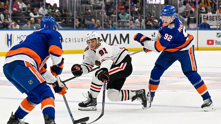 Oct 8, 2026; Elmont, New York, USA;  New York Islanders defenseman Adam Pelech (3) steals the puck from Chicago Blackhawks center Frank Nazar (91) defended by New York Islanders right wing Simon Holmstrom (92) during the first period at UBS Arena.  Mandatory Credit: Dennis Schneidler-Imagn Images