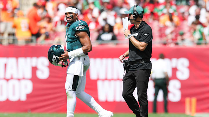Sep 28, 2025; Tampa, Florida, USA; Philadelphia Eagles offensive coach Kevin Patullo communicates with quarterback Jalen Hurts (1) during a timeout in the second quarter against the Tampa Bay Buccaneers at Raymond James Stadium. Mandatory Credit: Nathan Ray Seebeck-Imagn Images